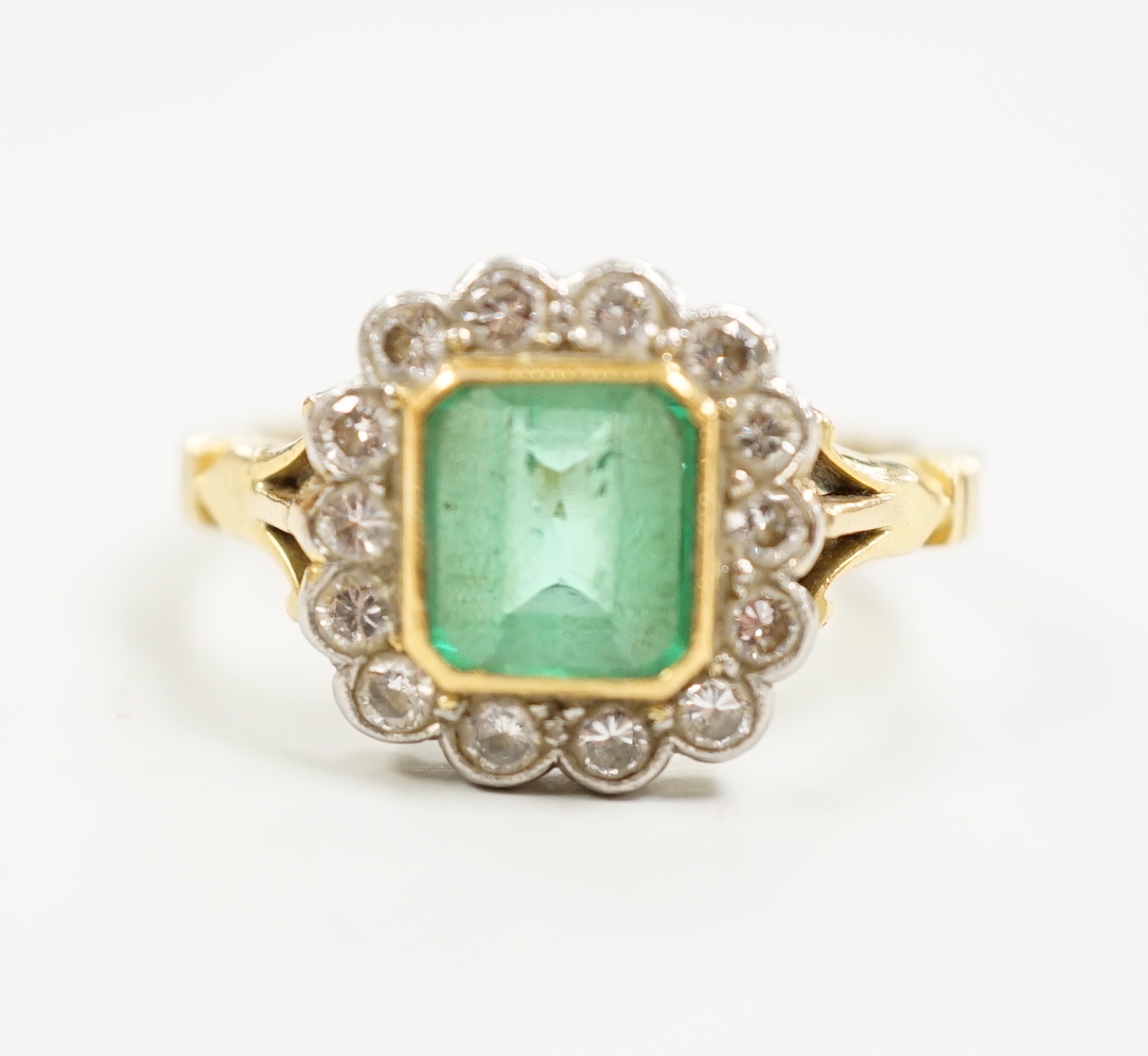 A modern 18ct gold, emerald and diamond set circular cluster ring, size O, gross weight 5 grams.